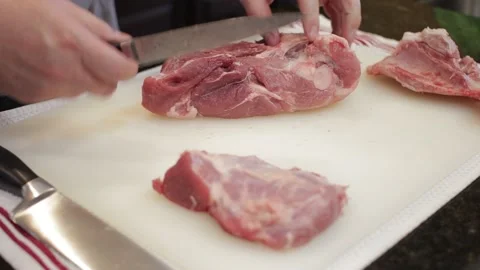 Man Cutting and trimming Large Pork Meat In A Kitchen With Two Knives Stock Footage 140614490