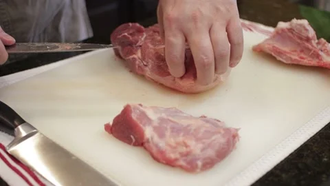 Man Cutting and trimming Large Pork Meat In A Kitchen With Two Knives Stock Footage 140614520