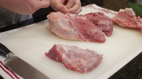 Man Cutting and trimming Large Pork Meat In A Kitchen With Two Knives Stock Footage 140614522