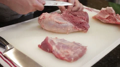 Man Cutting and trimming Large Pork Meat In A Kitchen With Two Knives Stock Footage 140614538