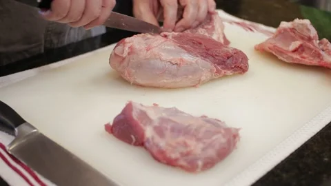 Man Cutting and trimming Large Pork Meat In A Kitchen With Two Knives Stock Footage 140614725