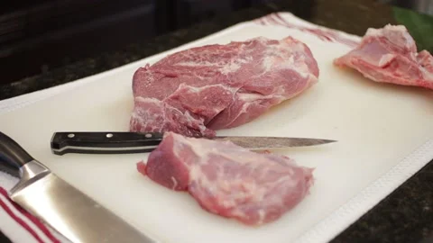 Man Cutting and trimming Large Pork Meat In A Kitchen With Two Knives Stock Footage 140614733