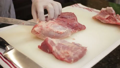 Man Cutting and trimming Large Pork Meat In A Kitchen With Two Knives Stock Footage 140614744