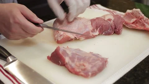 Man Cutting and trimming Large Pork Meat In A Kitchen With Two Knives Stock Footage 140614764