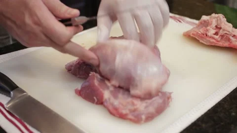 Man Cutting and trimming Large Pork Meat In A Kitchen With Two Knives Stock Footage 140614924