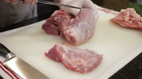 Man Cutting and trimming Large Pork Meat In A Kitchen With Two Knives Stock Footage 140614950