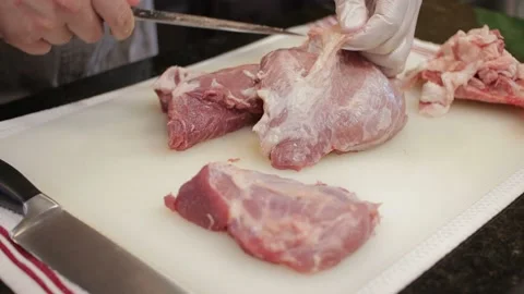 Man Cutting and trimming Large Pork Meat In A Kitchen With Two Knives Stock Footage 140615149