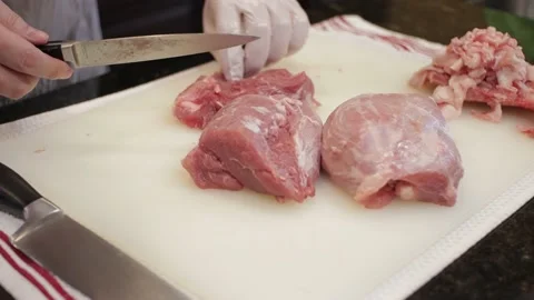 Man Cutting and trimming Large Pork Meat In A Kitchen With Two Knives Stock Footage 140615666
