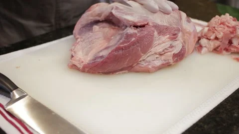 Man Cutting and trimming Large Pork Meat In A Kitchen With Two Knives Stock Footage 140615669