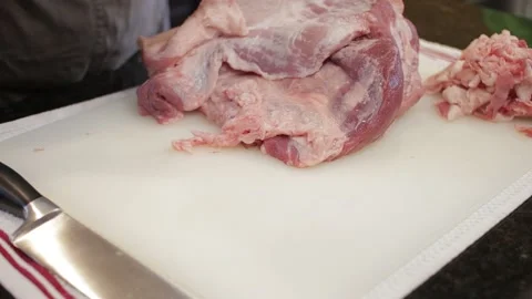 Man Cutting and trimming Large Pork Meat In A Kitchen With Two Knives Stock Footage 140616045