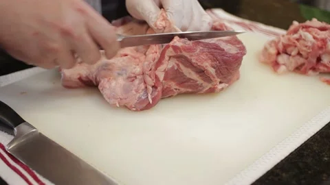 Man Cutting and trimming Large Pork Meat In A Kitchen With Two Knives Stock Footage 140616331