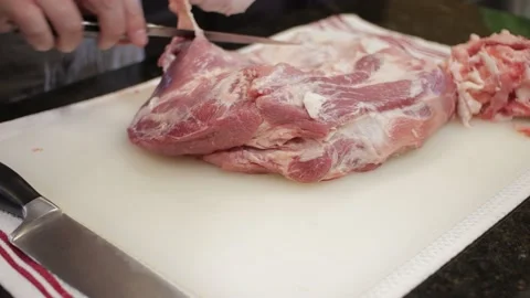 Man Cutting and trimming Large Pork Meat In A Kitchen With Two Knives Stock Footage 140616575