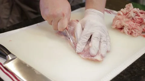 Man Cutting and trimming Large Pork Meat In A Kitchen With Two Knives Stock Footage 140616848