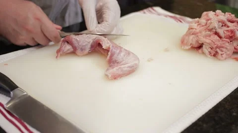 Man Cutting and trimming Large Pork Meat In A Kitchen With Two Knives Stock Footage 140617140