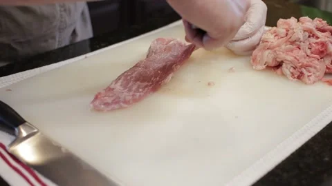 Man Cutting and trimming Large Pork Meat In A Kitchen With Two Knives Video stock 140617152