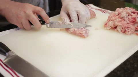 Man Cutting and trimming Large Pork Meat In A Kitchen With Two Knives Stock Footage 140617225