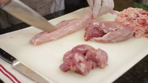 Man Cutting and trimming Large Pork Meat In A Kitchen With Two Knives Stock Footage 140617400