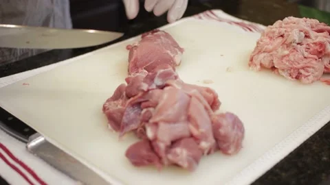 Man Cutting and trimming Large Pork Meat In A Kitchen With Two Knives Stock Footage 140617432