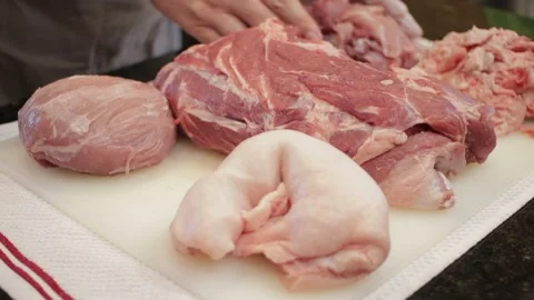 Man Cutting and trimming Large Pork Meat In A Kitchen With Two Knives Stock Footage 140617467