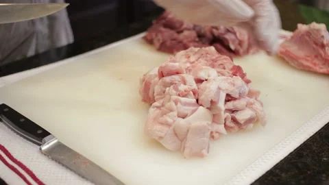 Man Cutting and trimming Large Pork Meat In A Kitchen With Two Knives Stock Footage 140617612