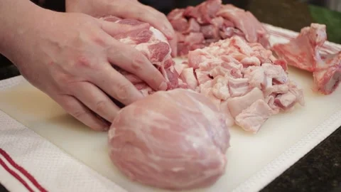 Man Cutting and trimming Large Pork Meat In A Kitchen With Two Knives Stock Footage 140617630