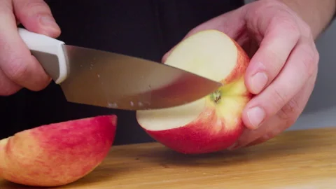 Man cutting apples on a cutting board close-up slow motion. Video stock 230741037