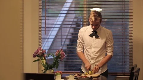 Man cutting a banana in the kitchen. 動画素材 72401236