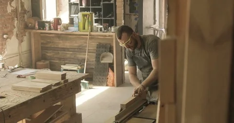 Man cutting boards with electric saw, in a carpentry workshop Stock Footage