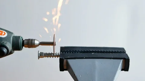 Man cutting a bolt clamped in vice with mini circular saw 動画素材 116057752