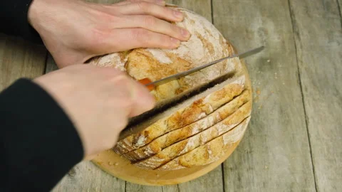 A man is cutting bread on the table. selective focus. Stock Footage 151409680