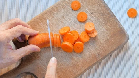 Man cutting carrot on table, close up Stock Footage 100764482