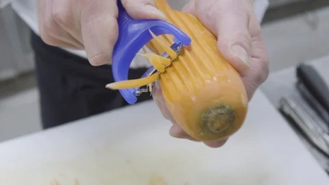 Man cutting carrots in kitchen Vídeos de archivo 104664297