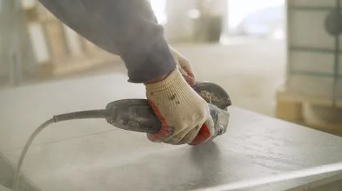 A man is cutting a ceramic tile with a tile cutter. Worker cutting a tile using Stock Photos