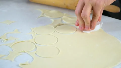 Man is cutting circles of dough for cooking dumplings using form, hands closeup. Video stock 152967115