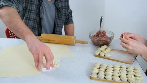 Man is cutting circles of dough for cooking dumplings using form, hands closeup. Video stock 152967122