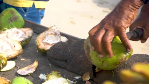 Man cutting a coconut with a big machete knife. Stock Footage
