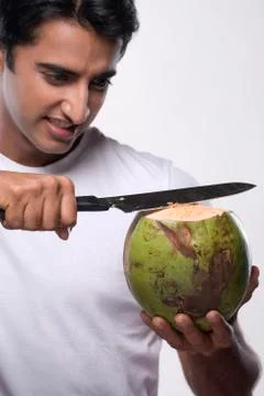 Man cutting a coconut Stock Photos