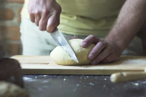 Man cutting dough into pieces, slow motion at 60 fps Stock Footage 31702234