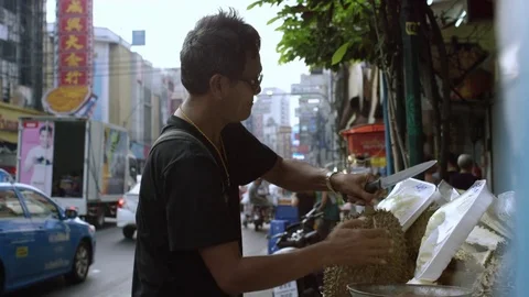 Man cutting durian fruit at the stall on street Stock Footage 73245676