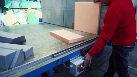 A man cutting foam rubber on the huge cutting machine, 4K Stockbeeldmateriaal 71812461