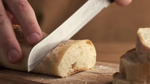 Man cutting fresh bread with a big knife Stock Footage 219001492