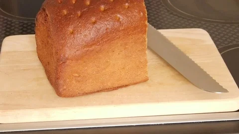 Man cutting fresh bread on a cutting board Stock Footage 72598390
