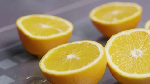 Man cutting fresh oranges into halves to make orange juice Stock Footage 85433744