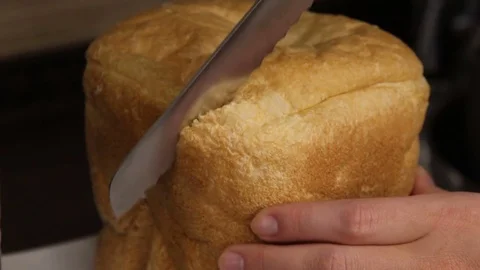 Man is cutting freshly cooked bread by knife Stock Footage 69911703