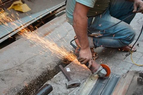 Man cutting Galvanized Iron Rolling Shutter Strip Stock Photos