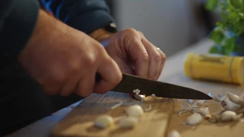 A man is cutting garlic on a cutting board Stock Footage 295367253