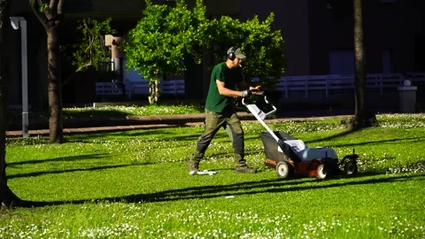 The man is cutting the grass in the garden Stock Footage 272636752