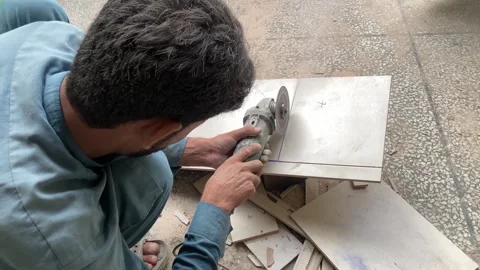 A man is cutting a hard tile with a cutter. Stock Footage 314119388