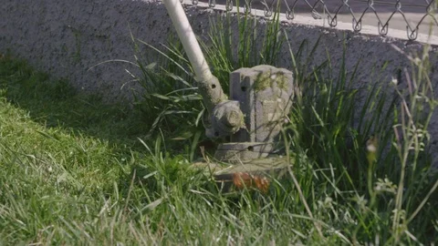 Man Cutting High Grass And Weeds With An Electric Garden Trimmer Stock Footage 126980841