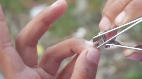 A man is cutting his fingernails using a metal nail clipper Stock Footage 333343113